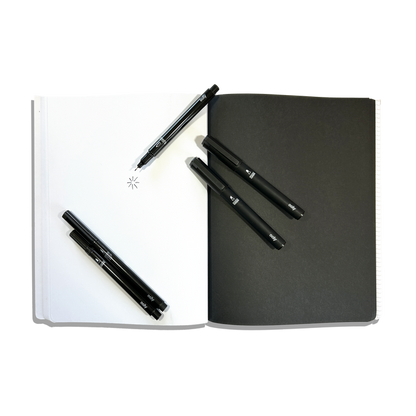 White and black paper pages in an opened OOLY's The Paper Works Sketchbook on a white background